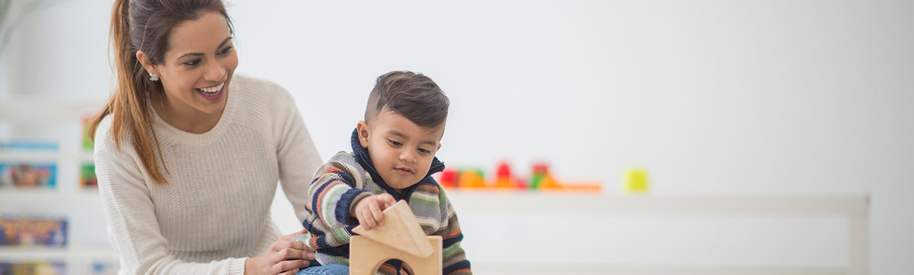 Mother and saying playing with toys in living room