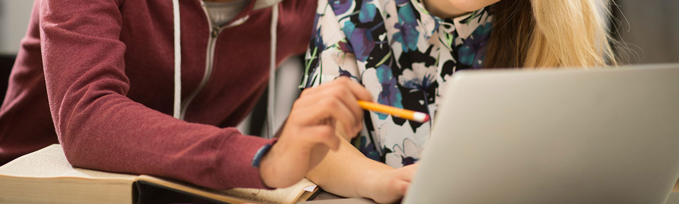 College students looking at work on computer