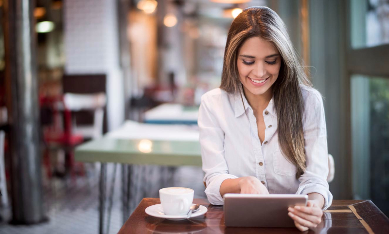 Young woman using tablet in coffee shop